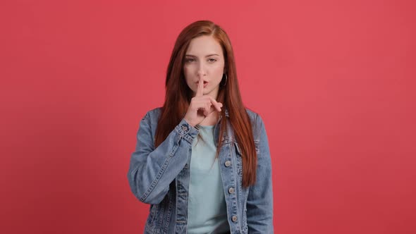 Girl Showing To Be Quiet with Finger Isolated on Red Background