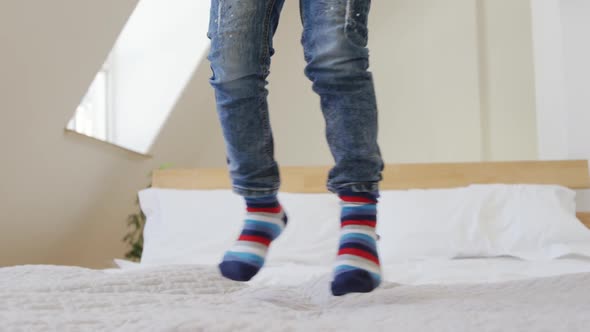 Young boy bouncing on bed