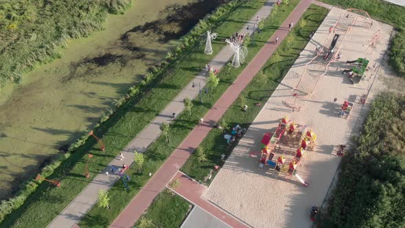 Outdoors playground for children. Kids playing on playground at sunny summer day at weekend.