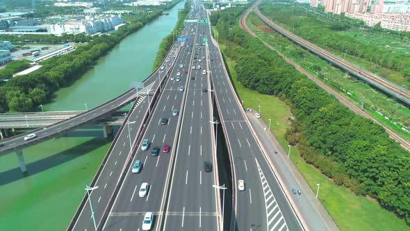 Aerial View of a Highway Overpass Multilevel Junction with Fast Moving Cars Surrounded By Green