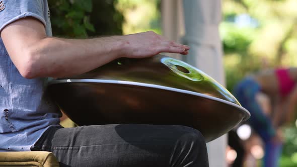 A Close Up of Male Hands Playing Handpan Drum