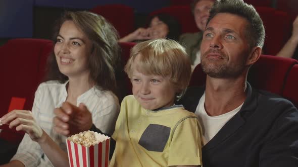 Family Enjoying Funny Movie in the Cinema
