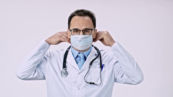 Handsome Male Doctor Put on Protective Mask Against Covid-19 Virus and Bacteria