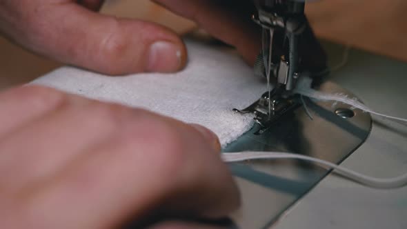 Tailor at Sewing Machine Sews a Homemade Medical Face Mask To Protect Covid-19