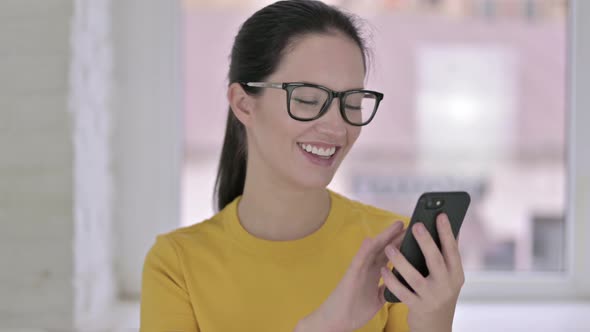 Portrait of Attractive Young Female Designer Using Smartphone