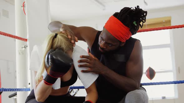 Trainer consoling female boxer in boxing ring 4k