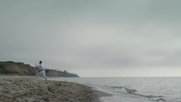 Professional Karate Man Training on Sandy Beach