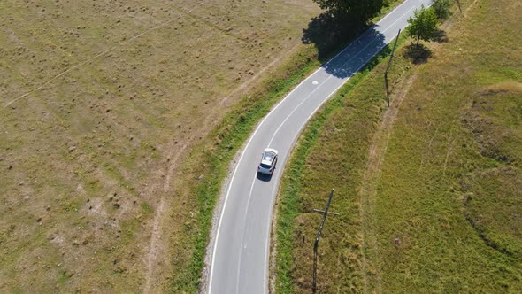 Driving car on rural empty road in 4K drone footage