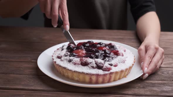 Woman is Cutting a Cake with Jelly Berries