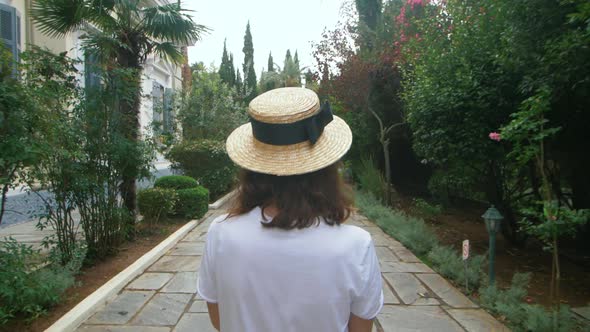 Tourist Woman Walking on Green Summer Park Back View. Young Woman in City Park