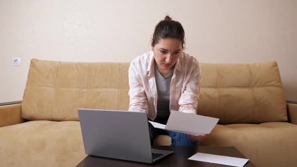 Emotional Woman with Bill Calculates Payments on Laptop