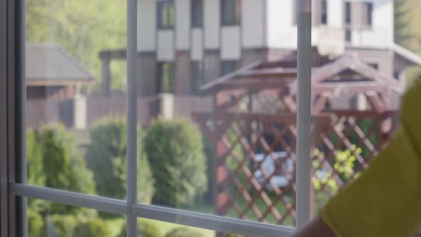 Close-up Woman in Rubber Gloves Washing Window, Rubs Dust with Rag, Housekeeping