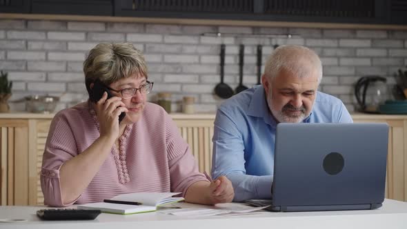 Pair of Retirees is Consulting By Phone Old Woman is Calling and Talking Husband is Surfing Internet