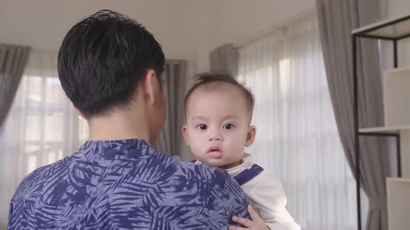 Asian Father Holding His Son At Home