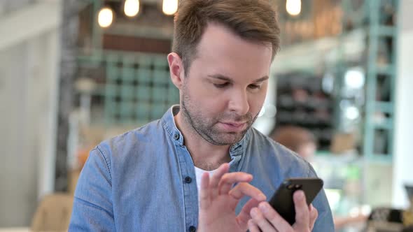 Portrait of Attractive Casual Man Using Smartphone