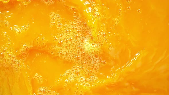 Super Slow Motion Shot of Swirling Fresh Orange Juice Background at 1000 Fps