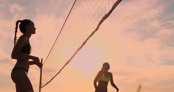 SLOW MOTION, LOW ANGLE, CLOSE UP, SUN FLARE: Athletic Girl Playing Beach Volleyball Jumps in the Air