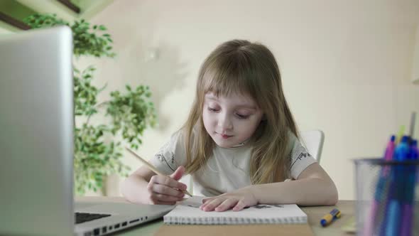 Cheerful Cute Preschool Child Little Girl Kid Drawing on Paper Using Laptop