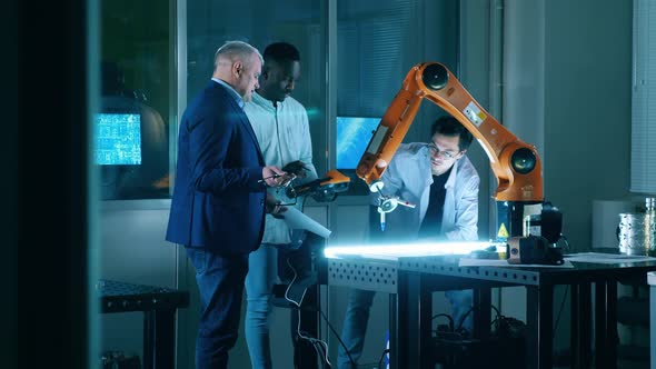 Robotic Laboratory with Engineers Researching a Robotic Device