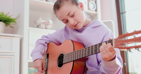 Teen Girl is Playing Guitar and Singing