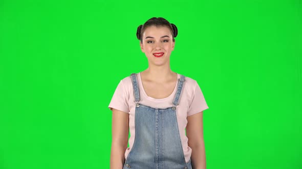 Portrait of Smiling Girl with Two Hair-buns on Green Screen