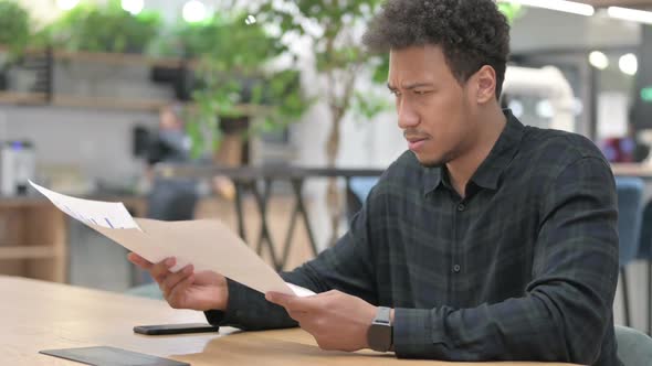 African American Man Having Loss While Reading Documents