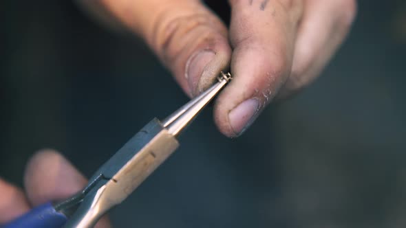 Jeweler Connects Gold Links to Chain at Workplace Close View