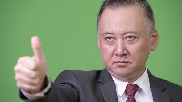 Mature Japanese Businessman Giving Thumbs Up