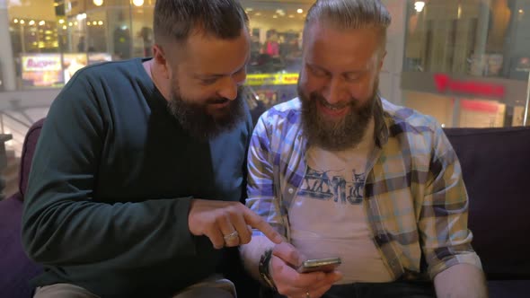 Close Up View of Two White Mature Bearded Men Using Smartphone Together