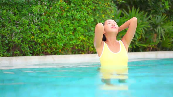 Young asian woman enjoy around outdoor swimming pool for leisure