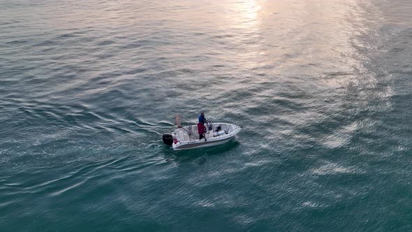 Fishing boat far out to sea at sunset