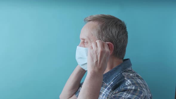 An Elderly Man Takes Off Surgical Mask