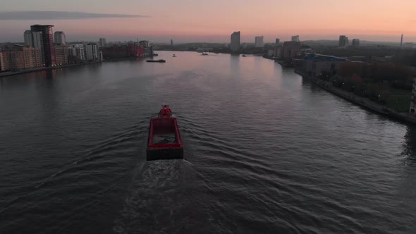 drone follow shot of Barge boat on the Thames river sunset