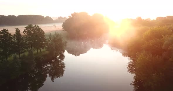 Aerial View of the River and Meadow Covered with Fog at Dawn