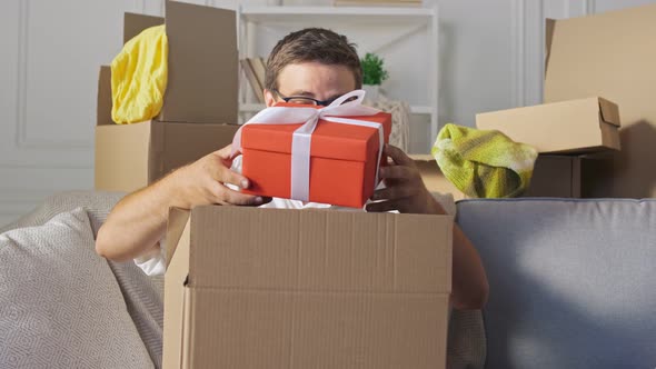 Man Opens Received Parcel in a Big Carton Box. Man Takes From a Big Carton Box a Present.