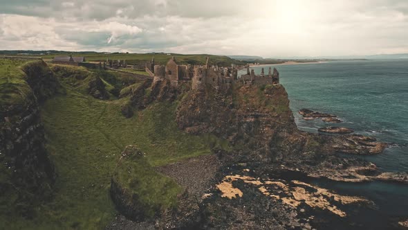 Old Castle Ruins at Sun Cliff Ocean Shore Aerial. Green Grass Valleys and Meadows at Ocean Bay