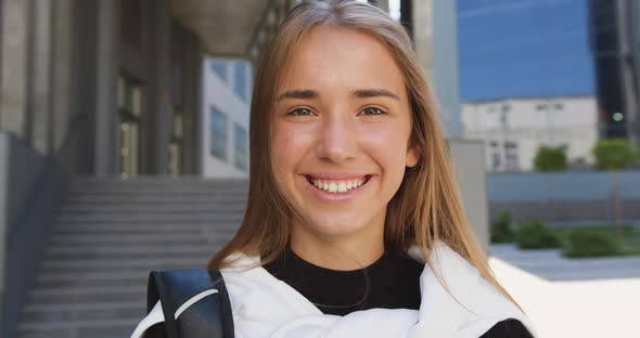 Modern Young Girl with Blond Hair in Casual Clothes Looking Into Camera