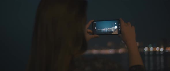 Woman taking pictures of a night city