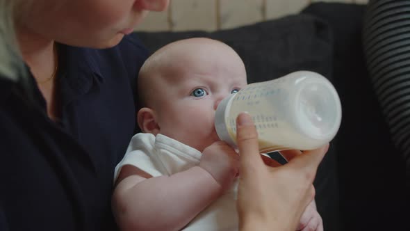 Blue Eyed Baby Girl Feeding From Bottle