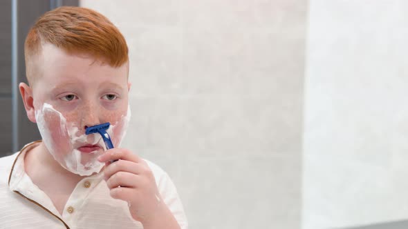 Little Boy is Shaving His Face in the Bathroom