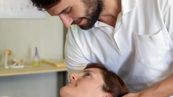 Physiotherapist giving head massage to a female patient