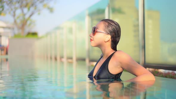 Young asian woman enjoy around outdoor swimming pool for leisure