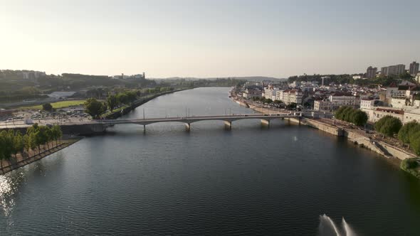 Bridge over Mondego River and riverside green city park, Coimbra , Aerial pullback