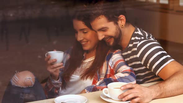 Happy couple interacting with each other while having coffee