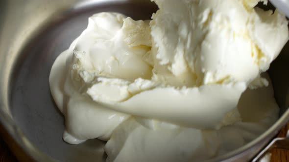 A woman makes cake cream in a bowl. Cooking white cream for pie, cake, dessert.