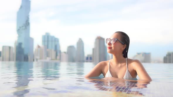 Young asian woman enjoy around outdoor swimming pool for leisure