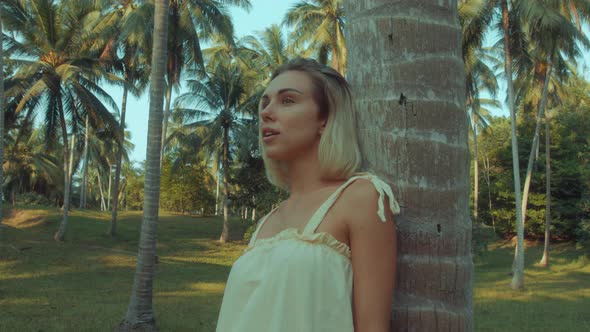 Young Blonde Standing Contemplating Tropical Rainforest Sunset Light Coming From Above