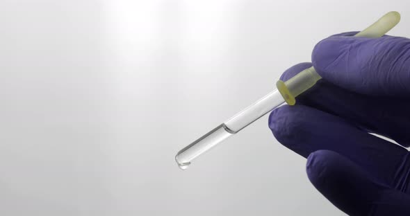 Hand in Medical Glove Drip Drop From Pipette. Close-up Video. Liquid Drop alt