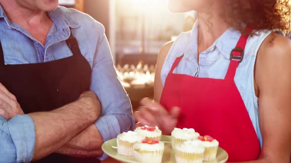 Smiling staff interacting at bakery counter