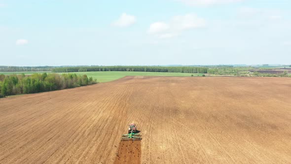 Aerial Flat View Tractor Plowing Field In Spring Season